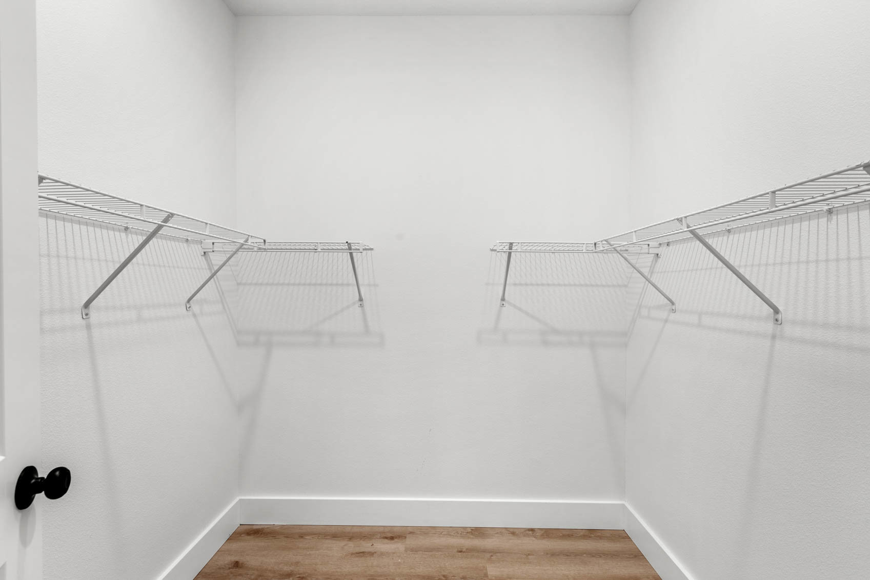walk in closet with white wire shelves